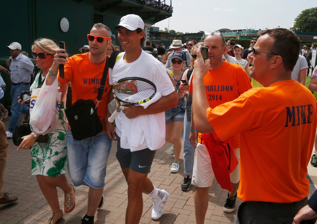 Rafael Nadal of Spain has his photo taken with members of the public on the first day at the All England Lawn Tennis Championships in Wimbledon, London, Monday June 23, 2014. (AP Photo/Pavel Golovkin)