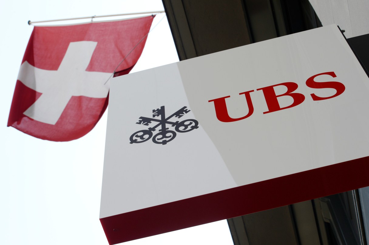 FILE - The April 24, 2014 file photo shows the logo of Swiss bank UBS and the Swiss flag in Zurich, Switzerland. Swiss banking giant UBS AG reported a 15 percent jump Tuesday July 29, 2014 in second-quarter net profit from a year ago, driven by strong results from its core wealth management and trimmed-down investment banking franchises despite a tough market environment. Switzerland's biggest bank said its net profit for the April-June period rose to 792 million Swiss francs (US$ 876 million), up from 690 million francs in the comparable period from 2013. (AP Photo/Keystone, Steffen Schmidt,File)