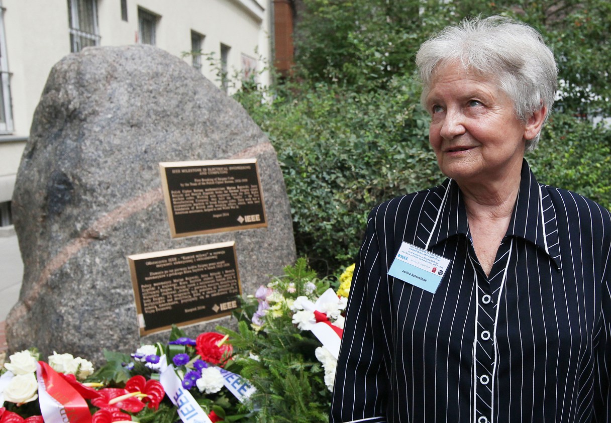 Janina Sylwestrzak, the daughter of Marian Rejewski, one of three Polish mathematicians who in 1932 broke the German Enigma cipher machine is talking to reporters in fron of a memorial plaque unveiled to the three scientists in Warsaw, Poland, Tuesday, Aug. 5, 2014. The late Rejewski, Jerzy Rozycki and Henryk Zygalski were honored on Tuesday with the “Milestone” distinction by the global Institute of Electrical and Electronics Engineers for helping the Allied victory and thus saving lives. (AP Photo/Czarek Sokolowski)