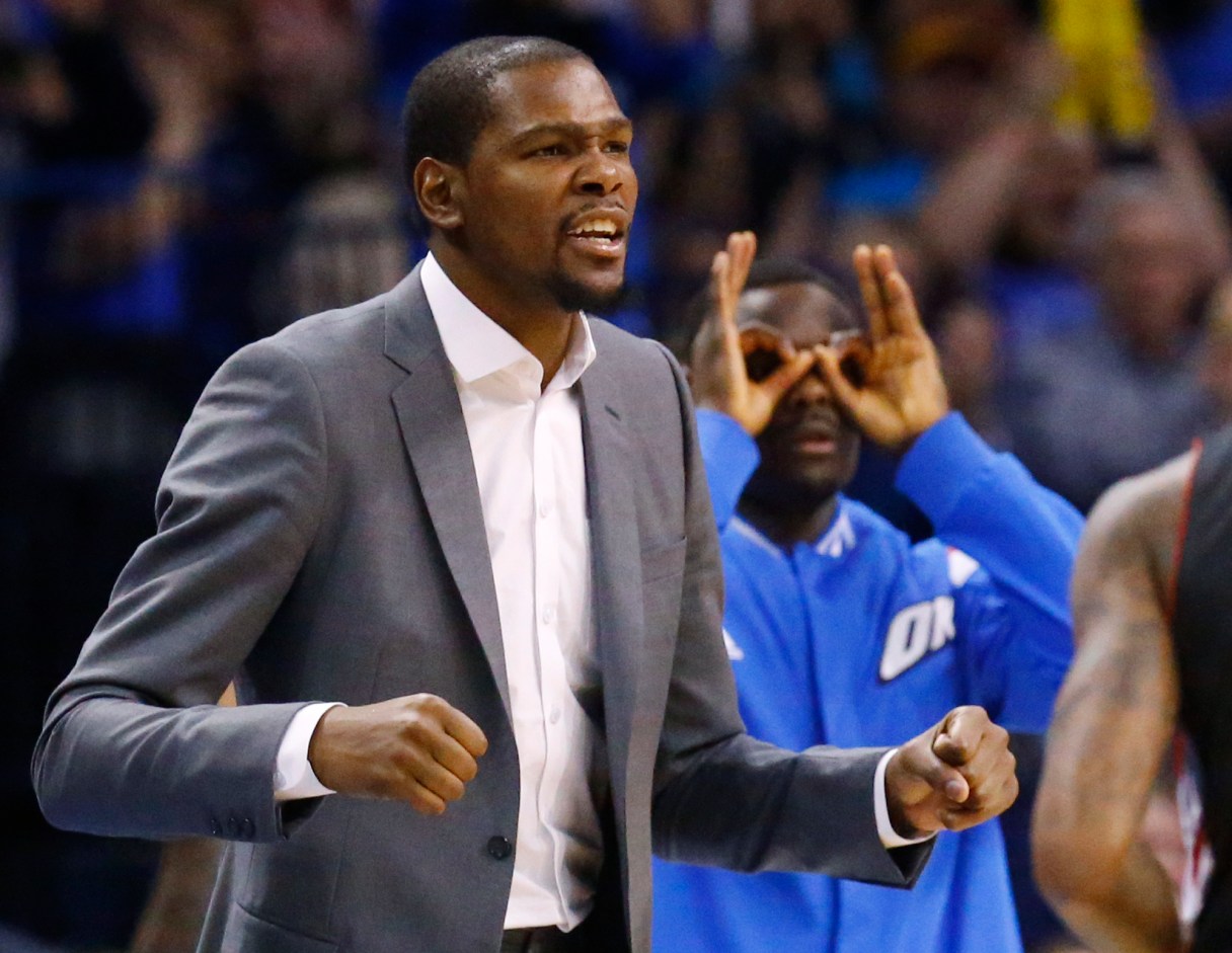 Injured Oklahoma City Thunder forward Kevin Durant reacts on the bench to a basket in the fourth quarter of an NBA basketball game against the Toronto Raptors in Oklahoma City, Sunday, March 8, 2015. Oklahoma City won 108-104. (AP Photo/Sue Ogrocki)