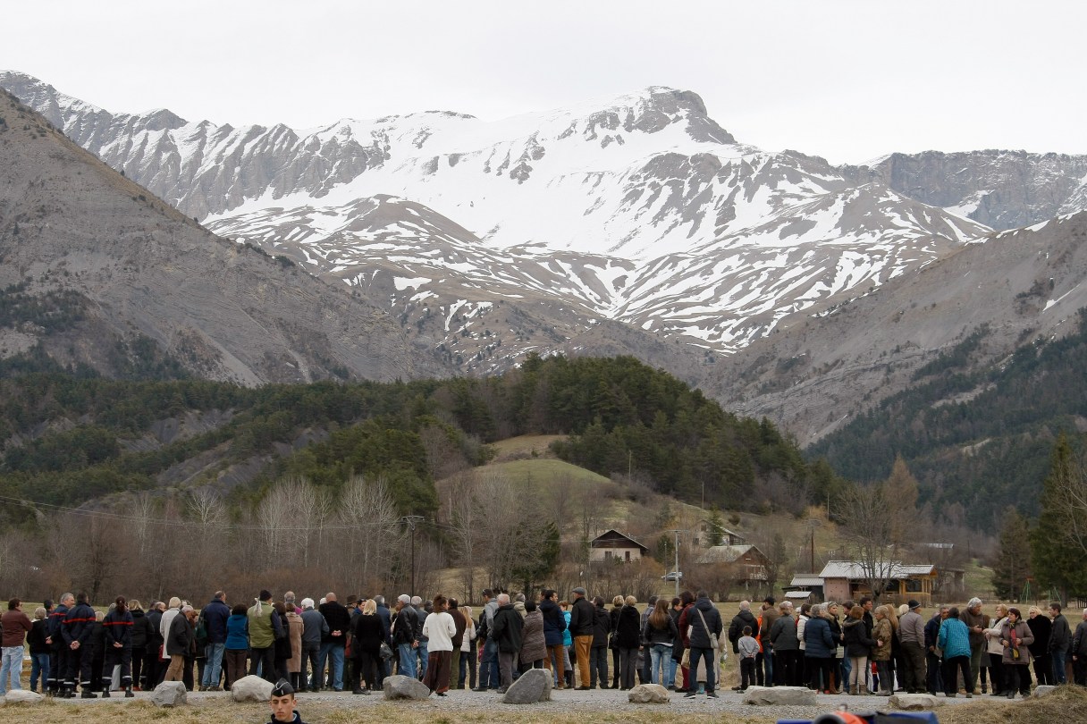 Inhabitants pay tribute to the victims in front of a stele, a stone slab erected as a monument, set up in the area where a Germanwings aircraft crashed in the French Alps, in Le Vernet, France, Saturday, March 28, 2015. The crash of Germanwings Flight 9525 into an Alpine mountain Tuesday killed all 150 people aboard, and has raised questions about the mental state of the co-pilot. Authorities believe the 27-year-old German deliberately sought to destroy the Airbus A320 as it flew from Barcelona to Duesseldorf. (AP Photo/Claude Paris)