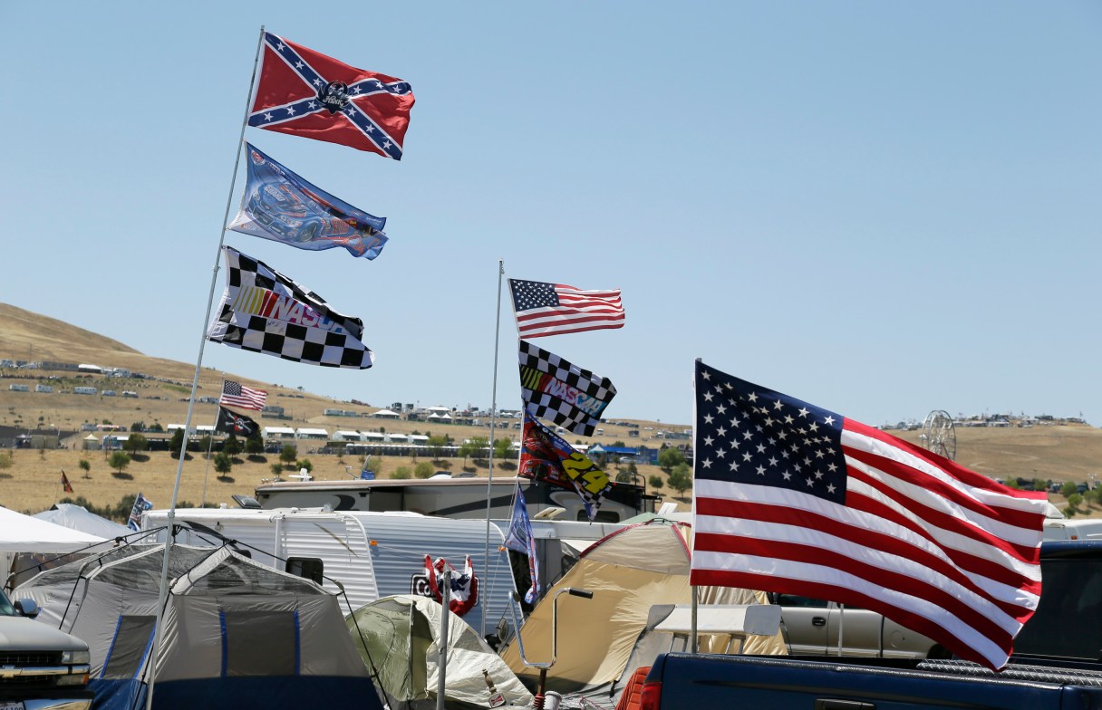 A number of flags, including a Confederate themed one, fly atop RV's in a campground outside the track during practice for the NASCAR Sprint Cup Series auto race Friday, June 26, 2015, in Sonoma, Calif. (AP Photo/Eric Risberg)
