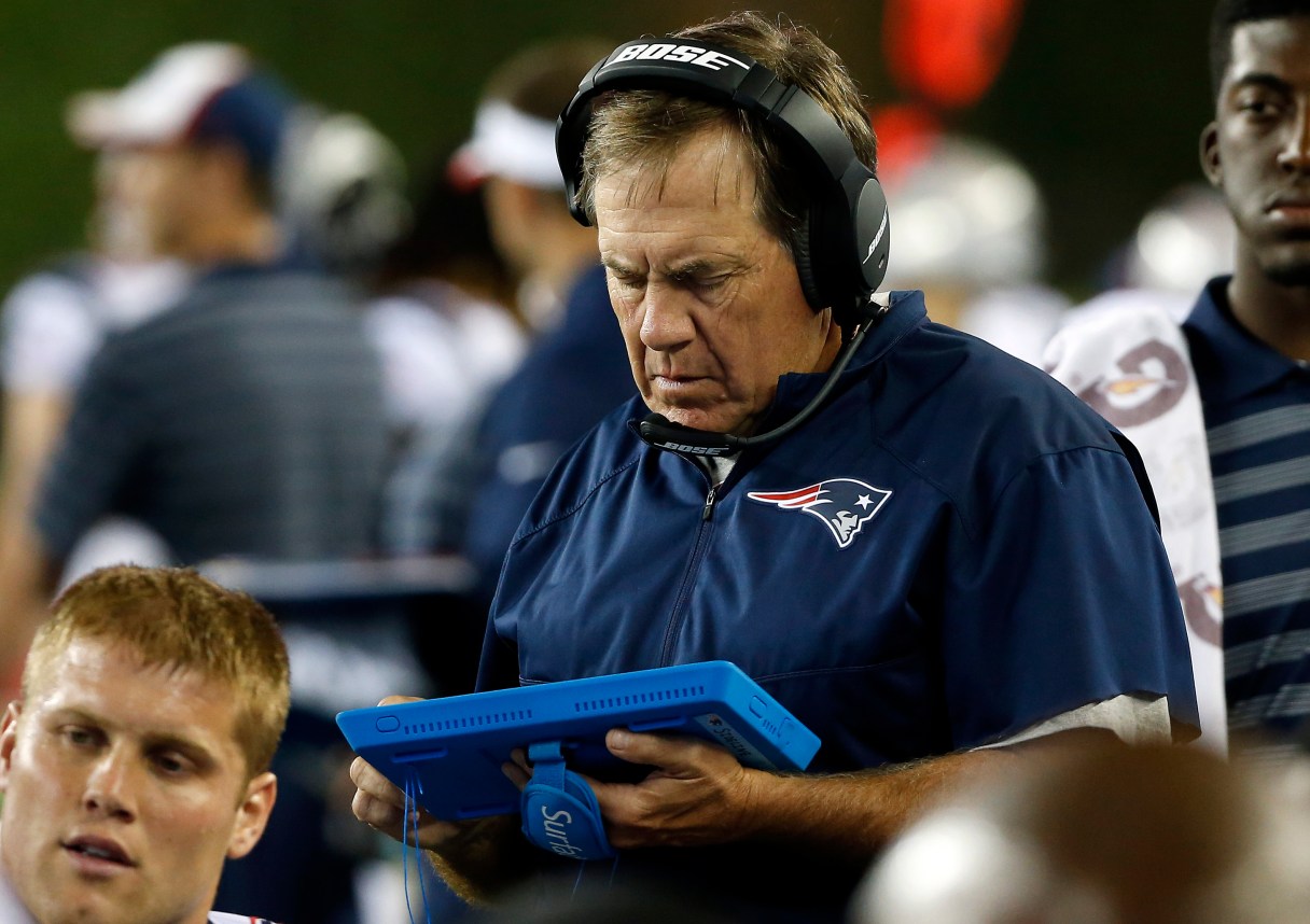 FILE - In this Aug. 15, 2014, file photo, New England Patriots head coach Bill Belichick studies a tablet device on the sideline in the first half of an NFL preseason football game against the Philadelphia Eagles in Foxborough, Mass. Coaches, players and game officials will be allowed to examine video on the sideline during 2015 preseason games. And there's a chance they will be able to do so in the regular season by 2016. (AP Photo/Elise Amendola, File)
