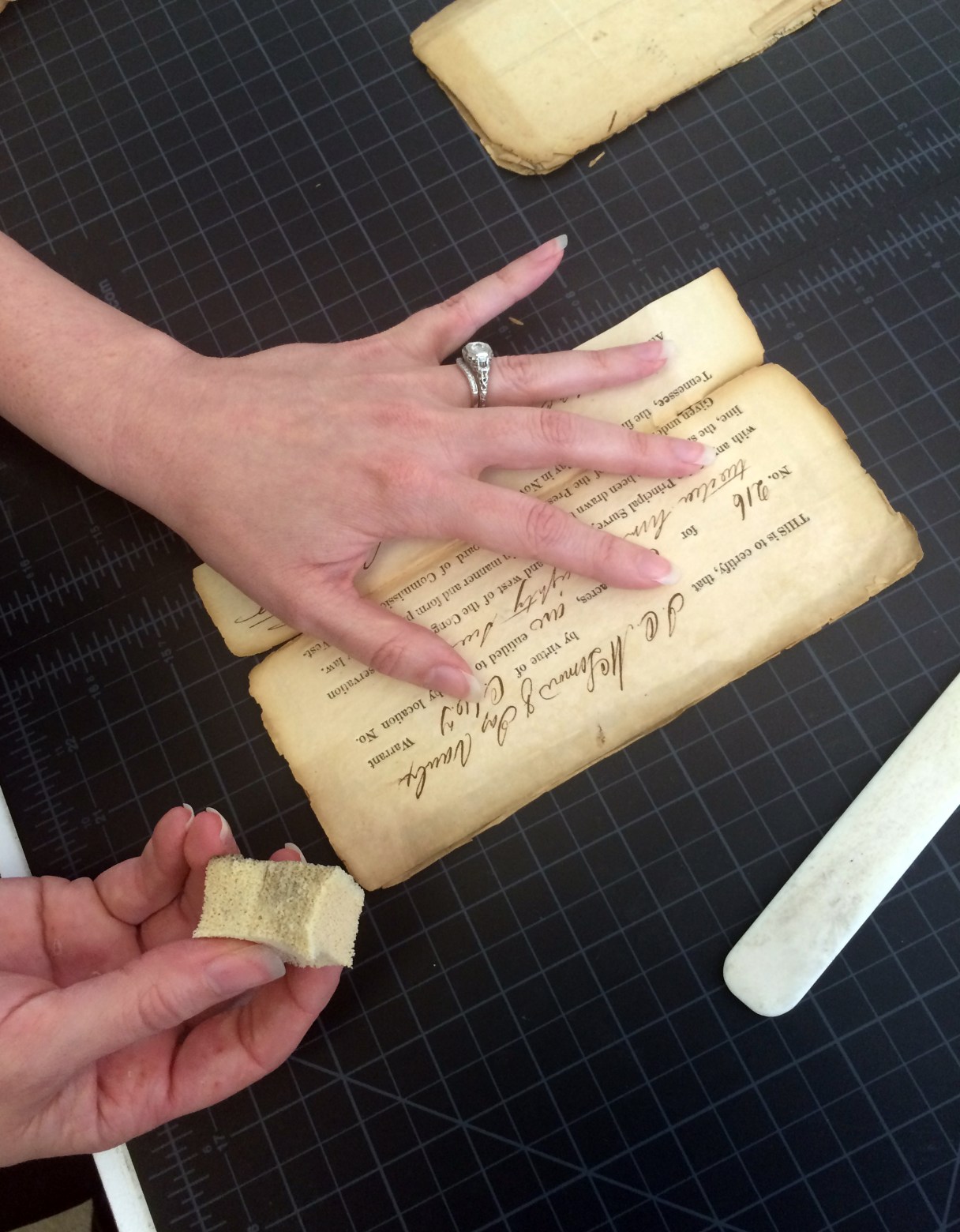 ADVANCE FOR USE SATURDAY, AUG. 8 - In this photo taken July 8, 2015, Kat Trammell, an intern at Tennessee State Library and Archives, uses a small sponge to surface-clean a Tennessee land record at the department of the Tennessee State Library and Archives in Nashville, Tenn. (Macaela Bennett/The Tennessean via AP) NO SALES; MANDATORY CREDIT