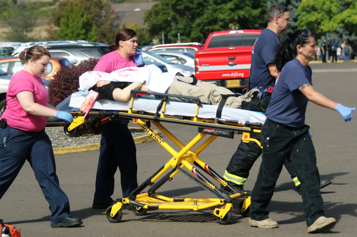 Authorities carry a shooting victim away from the scene after a gunman opened fire at Umpqua Community College in Roseburg, Ore., Thursday, Oct. 1, 2015. (Mike Sullivan/Roseburg News-Review via AP)