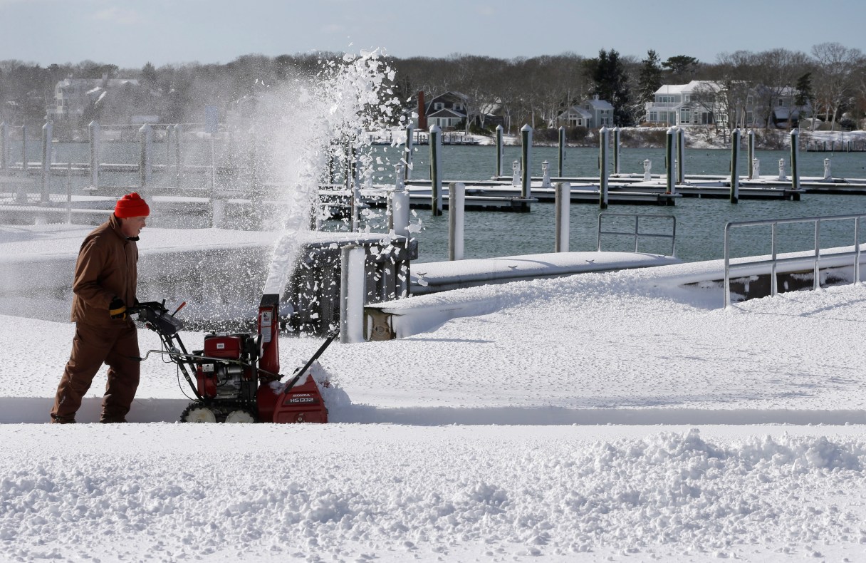 Fred Leach, of East Falmouth, Mass., creates a path with a snowblower at Green Pond Marina, Sunday, Jan. 24, 2016, in East Falmouth. A massive winter storm buried much of the U.S. East Coast in a foot or more of snow Saturday. (AP Photo/Steven Senne)