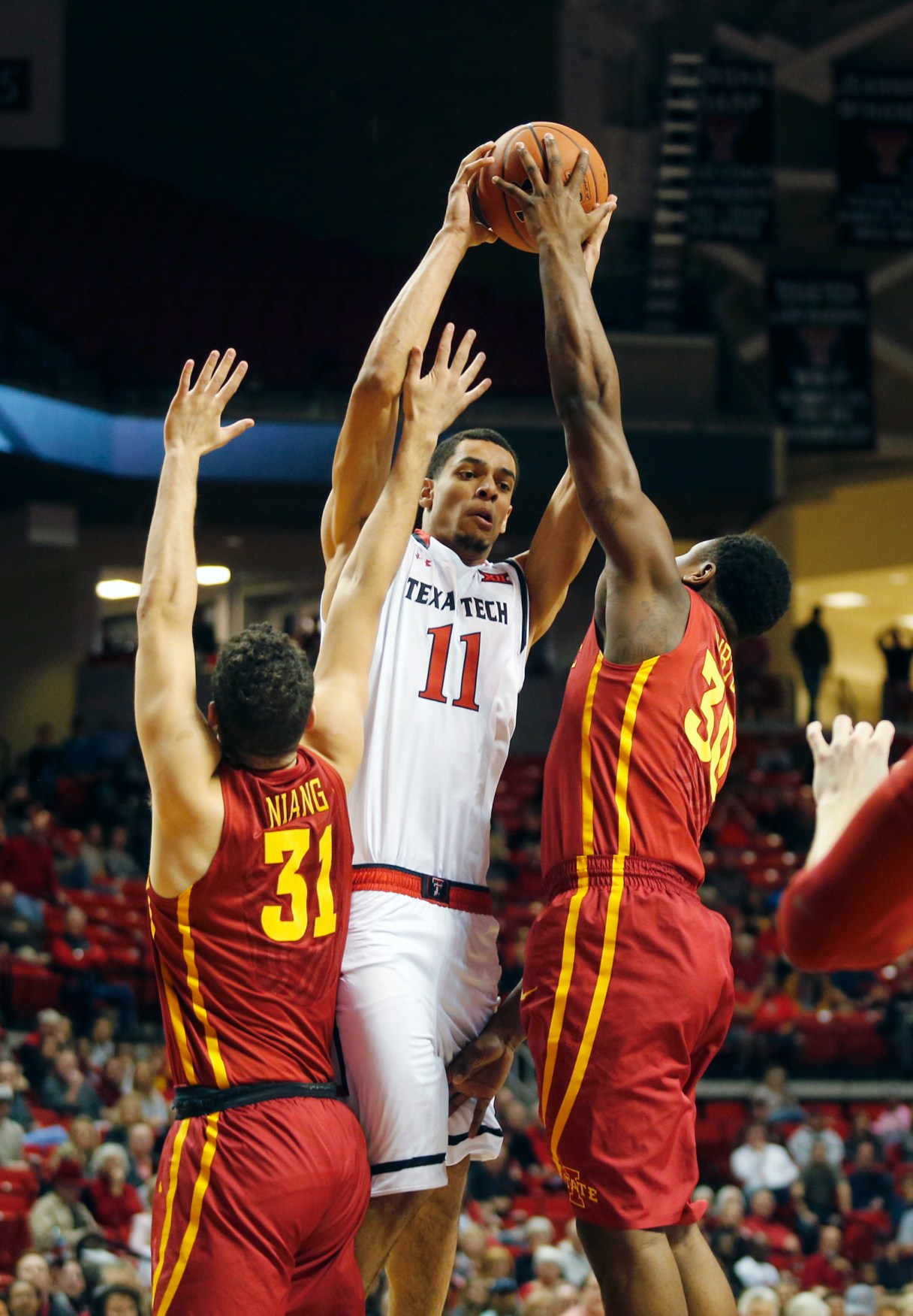 Texas Tech forward Zach Smith (11) pulls in a rebound between Iowa State forward Georges Niang (31) and Deonte Burton during the first half of an NCAA college basketball game, Wednesday, Feb. 10, 2016, in Lubbock, Texas. (AP Photo/Mark Rogers)