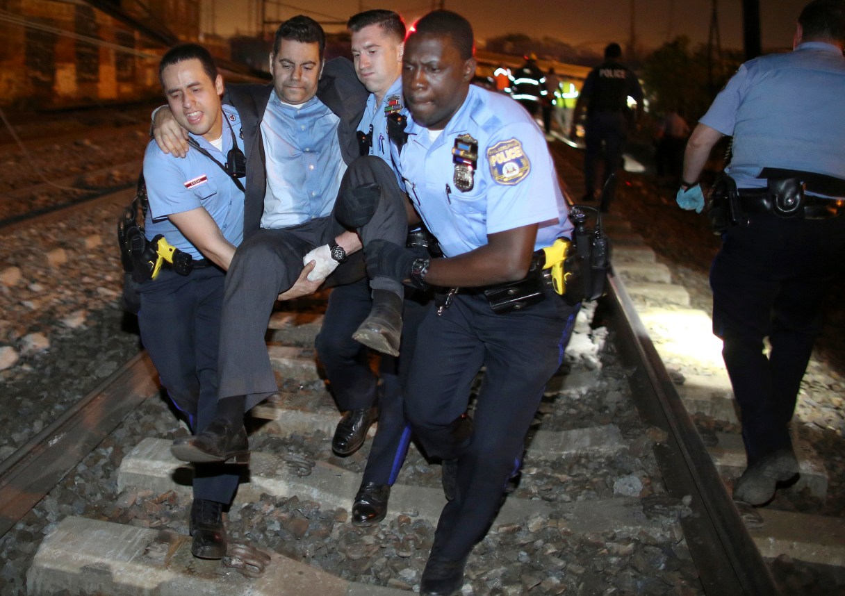 FILE - In this Tuesday, May 12, 2015 file photo, emergency personnel help a passenger in Philadelphia after the derailment in Philadelphia of an Amtrak train headed to New York. The National Transportation Safety Board is scheduled to meet Tuesday, May 17, 2016, to detail the probable cause of last year's fatal derailment. (AP Photo/Joseph Kaczmarek, File)