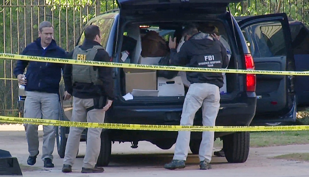 FILE - In this April 10, 2014, file photo taken from video, FBI agents collect evidence at an apartment complex in Atlanta, where federal agents rescued kidnap victim Frank Janssen, of Wake Forest, N.C. Kelvin Melton, a violent criminal described as a high-ranking member of the Bloods street gang goes on trial Monday, June 6, 2016, in North Carolina on a federal kidnapping charge after authorities say he helped orchestrate the abduction of Janssen, a prosecutor's father, from his prison cell. (AP Photo/Johnny Clark, File)