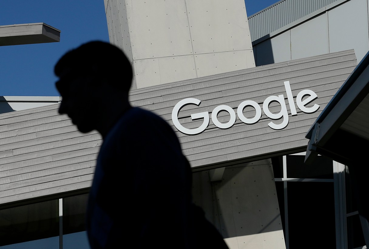 FILE - In this Nov. 12, 2015, file photo, a man walks past a building on the Google campus in Mountain View, Calif. Google and LinkedIn said July 13, 2016, that they have completed a massive land swap involving several Silicon Valley properties. (AP Photo/Jeff Chiu, File)