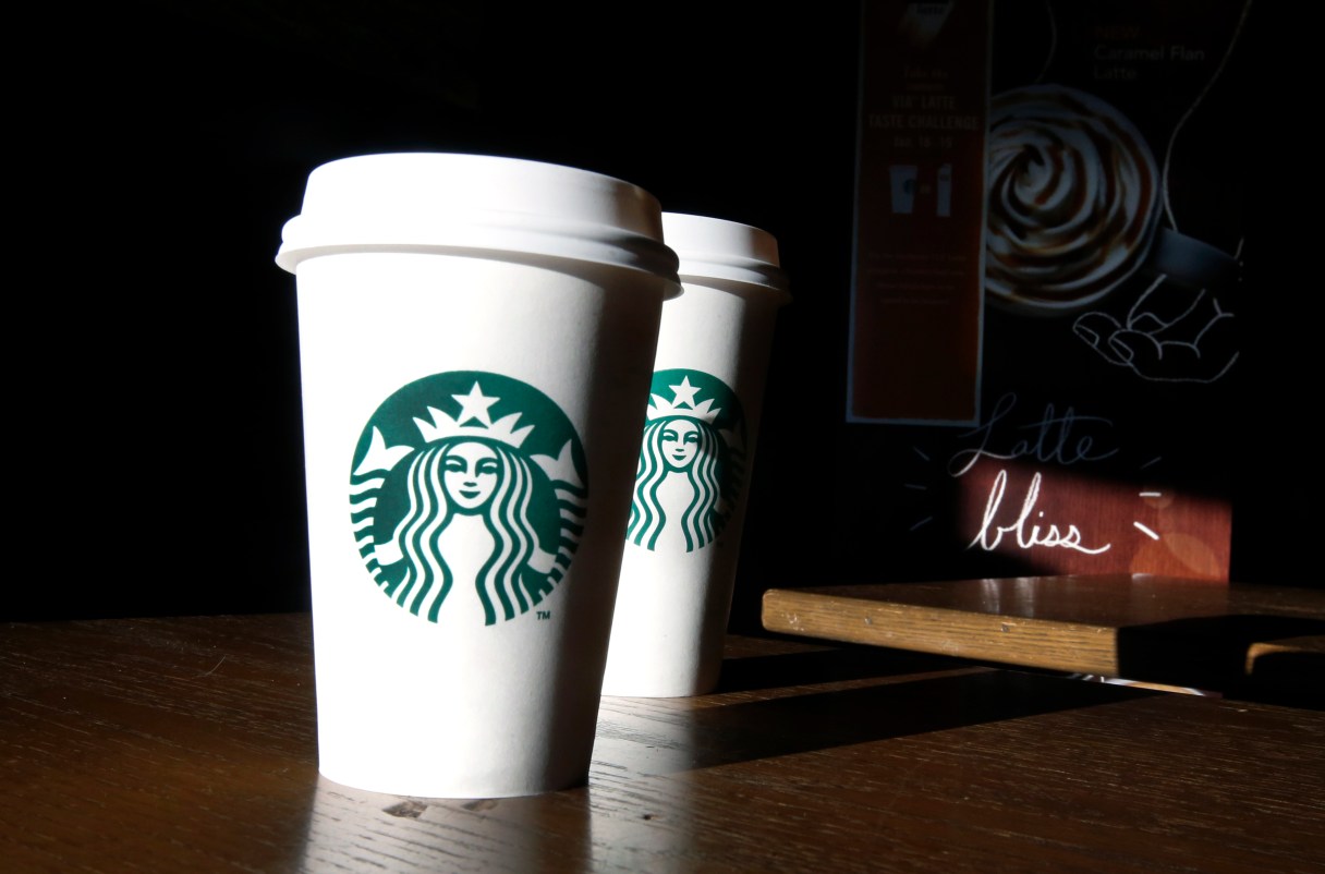FILE - In this this Friday, Jan. 17, 2014, file photo, Starbucks cups are shown mugs in a cafe in North Andover, Mass. Starbucks announced July 12, 2016, that it was raising prices slightly on brewed coffee, espresso and tea lattes in U.S. company-operated stores. (AP Photo/Elise Amendola, File)