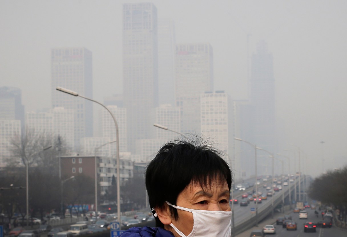 FILE - In this Dec. 20, 2015 file photo, a woman wearing a mask for protection against pollution walks on a pedestrian overhead bridge as office buildings are shrouded with smog in Beijing. More than nine out of 10 people worldwide live in areas with excessive air pollution, contributing to problems like strokes, heart disease and lung cancer, the World Health Organization said Tuesday, Sept. 27, 2016. The U.N. health agency said in a new report that 92 percent of people live in areas where air quality exceeds WHO limits, with southeast Asia, eastern Mediterranean and western Pacific regions hardest hit. (AP Photo/Andy Wong, File)