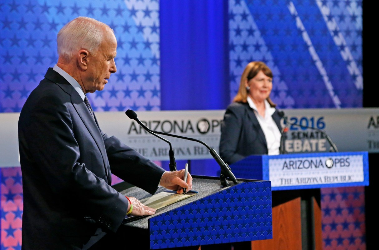 Incumbent Republican Sen. John McCain, left, takes a few notes as Arizona Democratic Rep. Ann Kirkpatrick speaks to the debate moderators prior to their only scheduled debate Monday, Oct. 10, 2016, in Phoenix before next month's general election. (AP Photo/Ross D. Franklin)