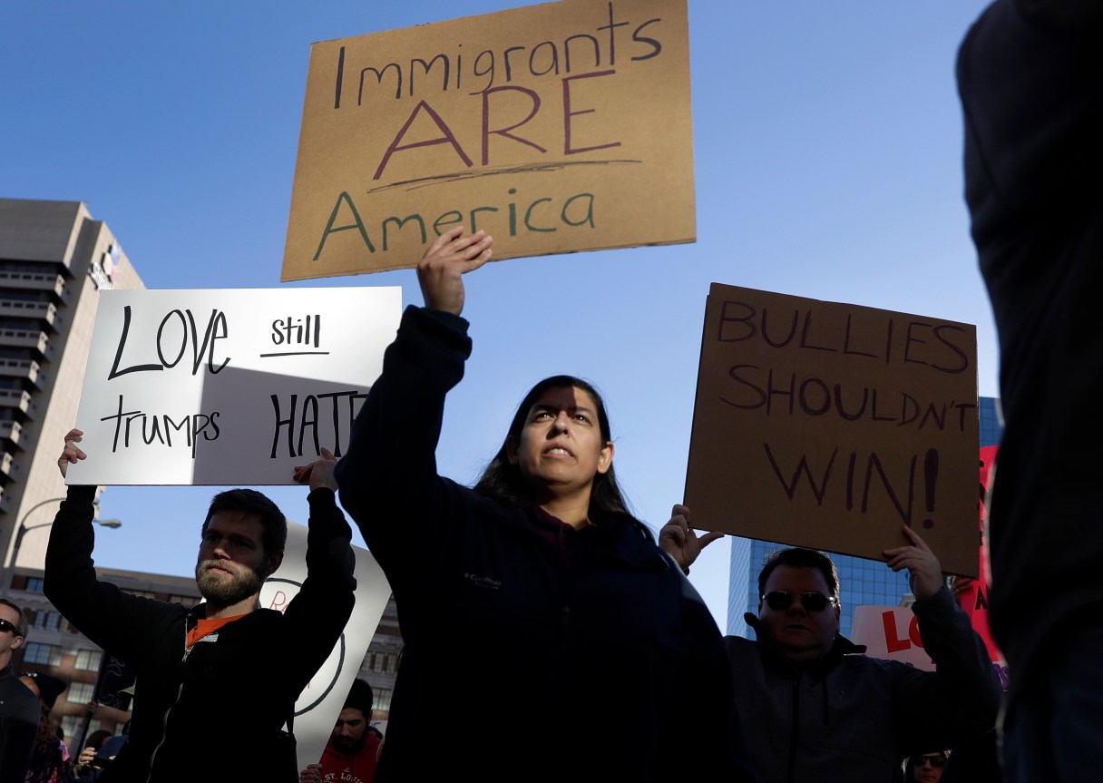 Protesters hold signs as they march in opposition to the election of President-elect Donald Trump on Sunday, Nov. 13, 2016, in St. Louis. Demonstrations also took place internationally. A group of Mexicans at statue representing independence in Mexico City expressed their concerns about a possible wave of deportations. (AP Photo/Jeff Roberson)