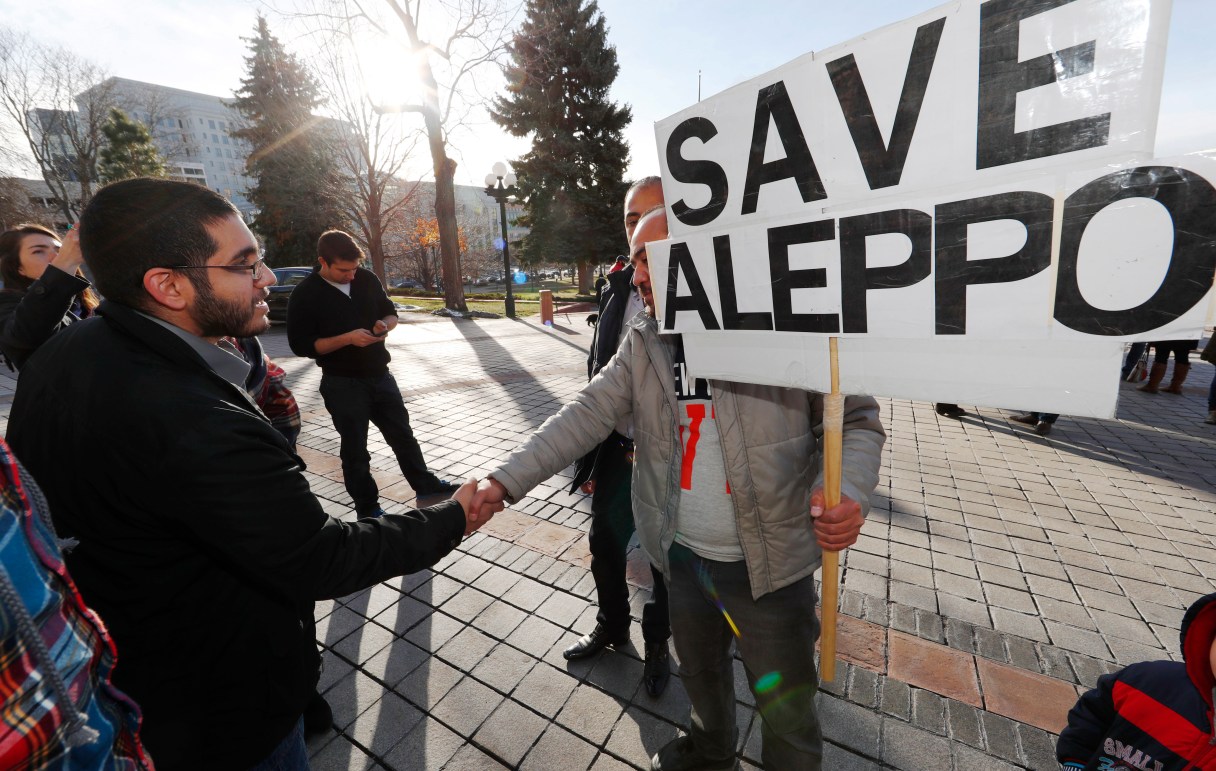Denver restaurateur Obeid Kaifo, left, greets a supporter after a protest outside the State Capitol Tuesday, Dec. 13, 2016, in downtown Denver. Protesters joined forces with four state lawmakers calling for the United States to take action to protect the people of Aleppo, Syria. Kaifo said that he has lost four family members during the fighting in Aleppo. (AP Photo/David Zalubowski)