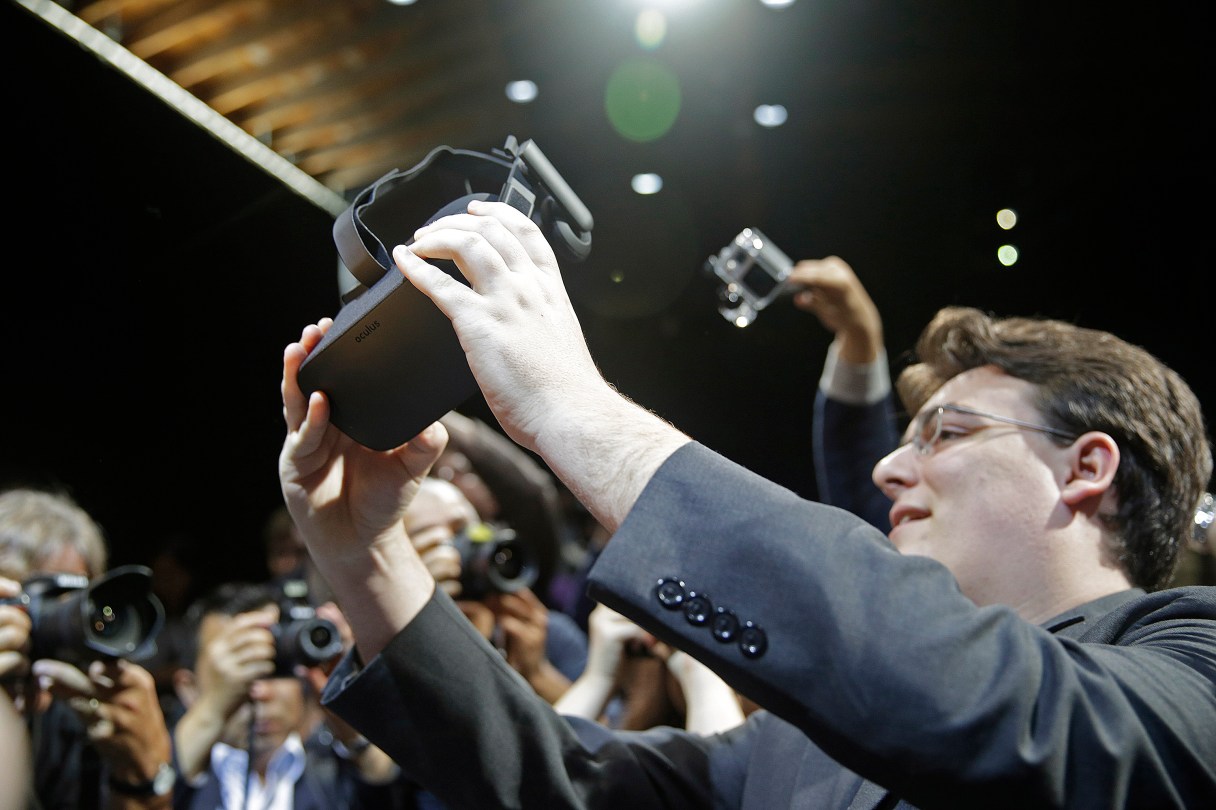 FILE - In this June 11, 2015, file photo, Oculus founder Palmer Luckey holds up the new Oculus Rift virtual reality headset for photographers following a news conference, in San Francisco. In a verdict reached Wednesday, Feb. 1, 2017, Facebook's virtual-reality subsidiary and two of its founders, Luckey and Brendan Iribe, are facing a sobering reality after a jury hit them with a $500 million bill for infringing on the rights of a video-game maker. (AP Photo/Eric Risberg, File)