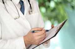 Medical doctor with a stethoscope around his neck holding