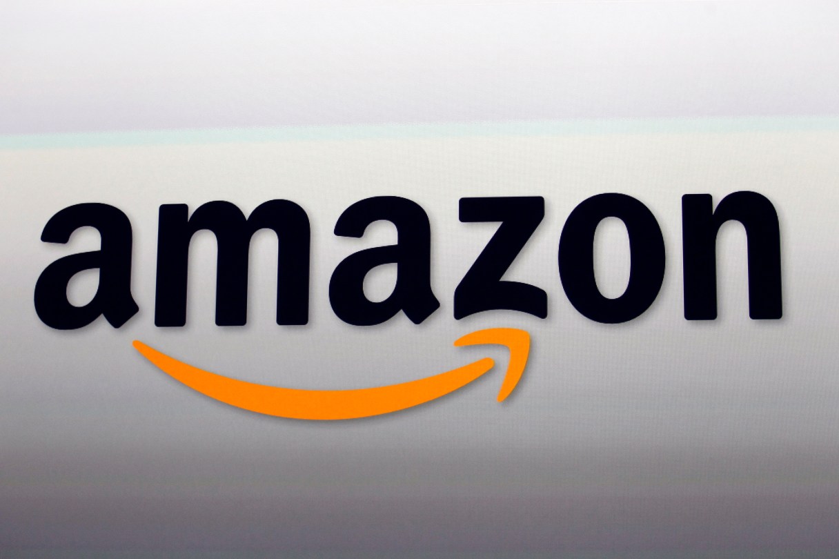 FILE - This Sept. 6, 2012, file photo, shows the Amazon logo in Santa Monica, Calif. Amazon is continuing to delve into new ways of letting people shop, this time with a grocery pickup service in Seattle called AmazonFresh Pickup. The service will let members of Amazon’s $99-a-year Prime loyalty program order groceries online, reserve a time to pick them up and then deliver them to a members’ car at the pickup location. (AP Photo/Reed Saxon, File)
