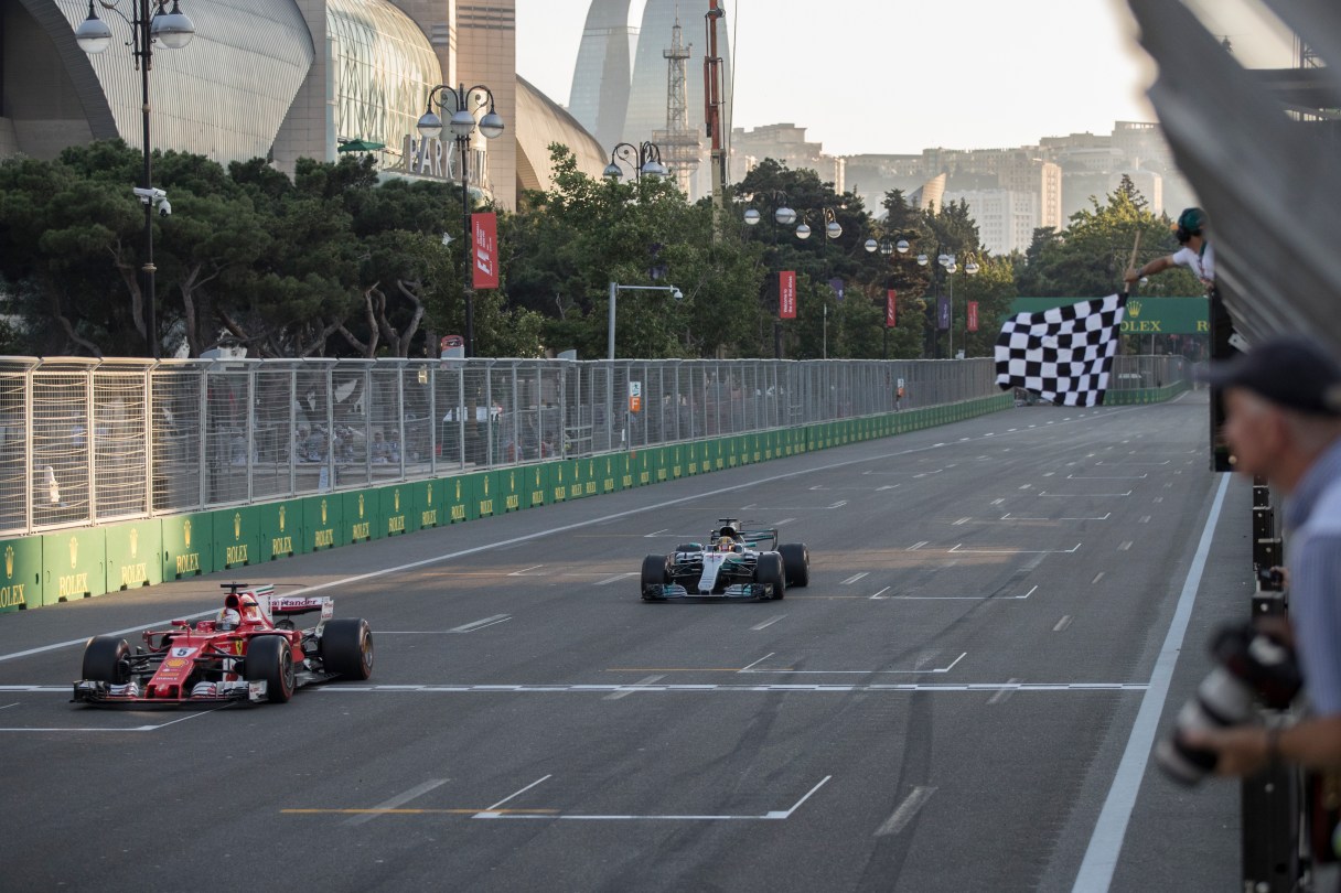 Ferrari driver Sebastian Vettel of Germany, left, and Mercedes driver Lewis Hamilton of Britain crosses the finish line at the Formula One Azerbaijan Grand Prix in Baku, Azerbaijan, Sunday, June 25, 2017. (Valdrin Xhemaj/Pool via AP)