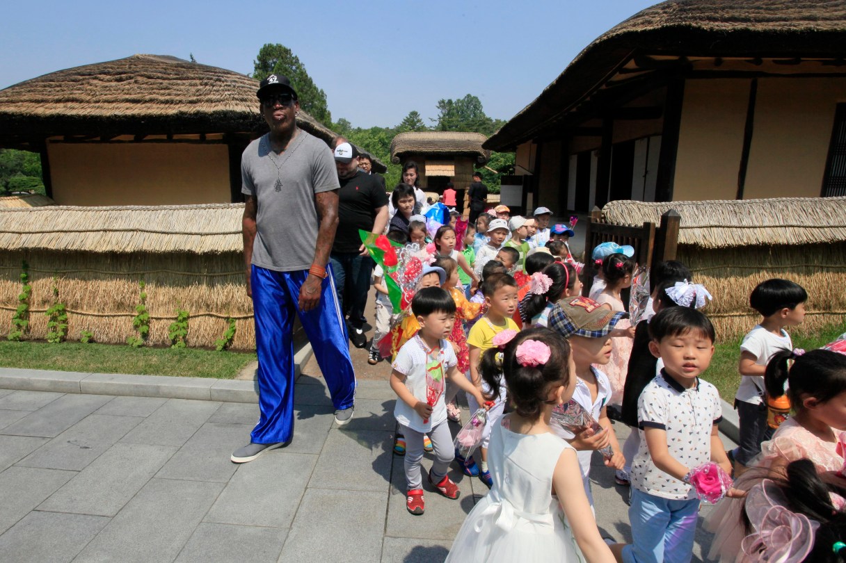 Former NBA basketball star Dennis Rodman, left, towers over North Korean children during his visit to Mangyongdae, the birth place of late North Korean leader Kim Il Sung on Wednesday, June 14, 2017, in Pyongyang, North Korea. Rodman's current trip is his first since Trump became president. He told reporters in Beijing, as he departed for Pyongyang, that he hopes his trip will "open a door" for Trump. (AP Photo/Kim Kwang Hyon)