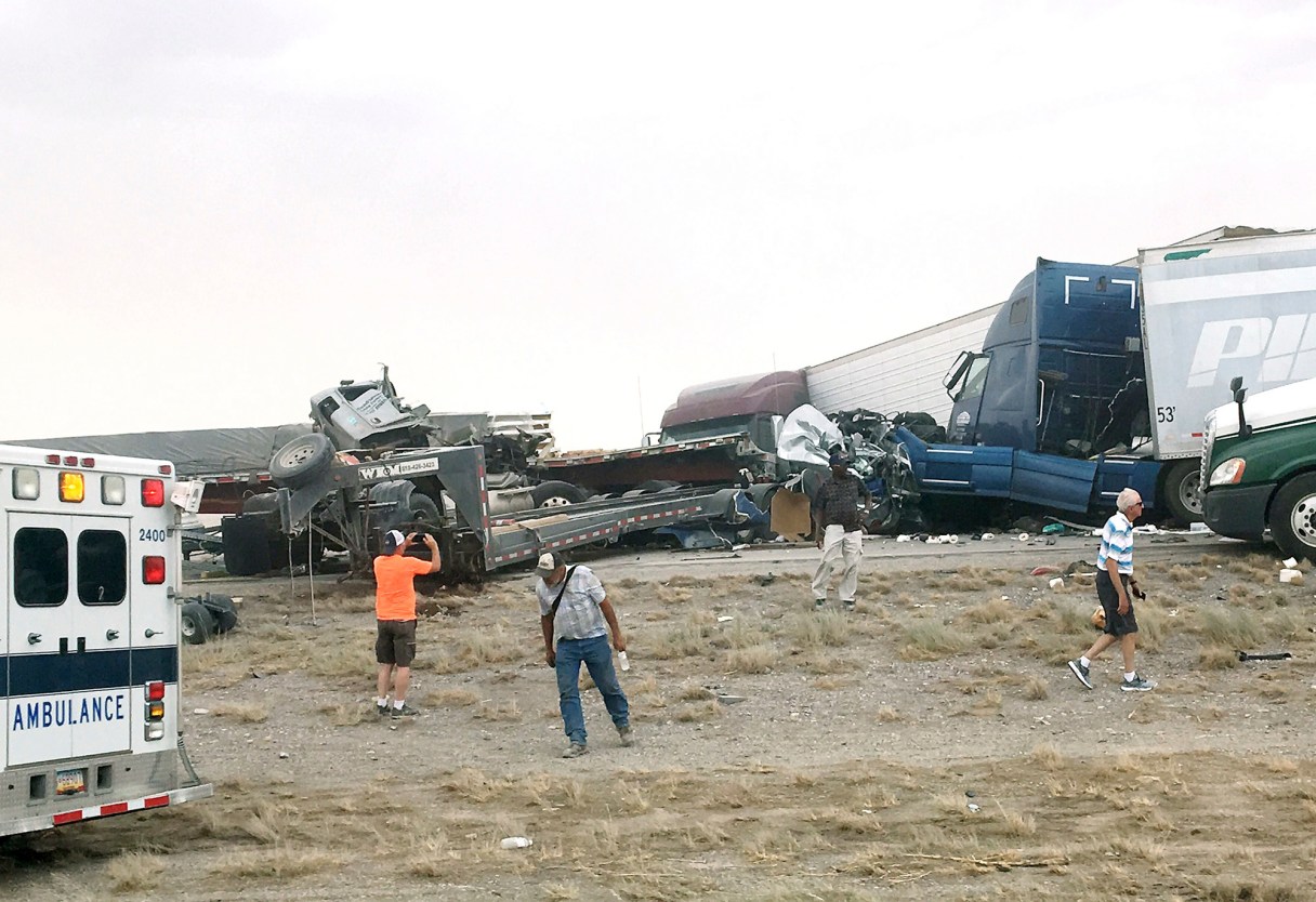 This photo provided by Robert Yacone, shows people walking around the scene where Interstate 10 was closed in southeastern Arizona due to blowing dust in the area and a vehicle crash, Monday, June 19, 2017, near Wilcox, Ariz. (Robert Yacone via AP)