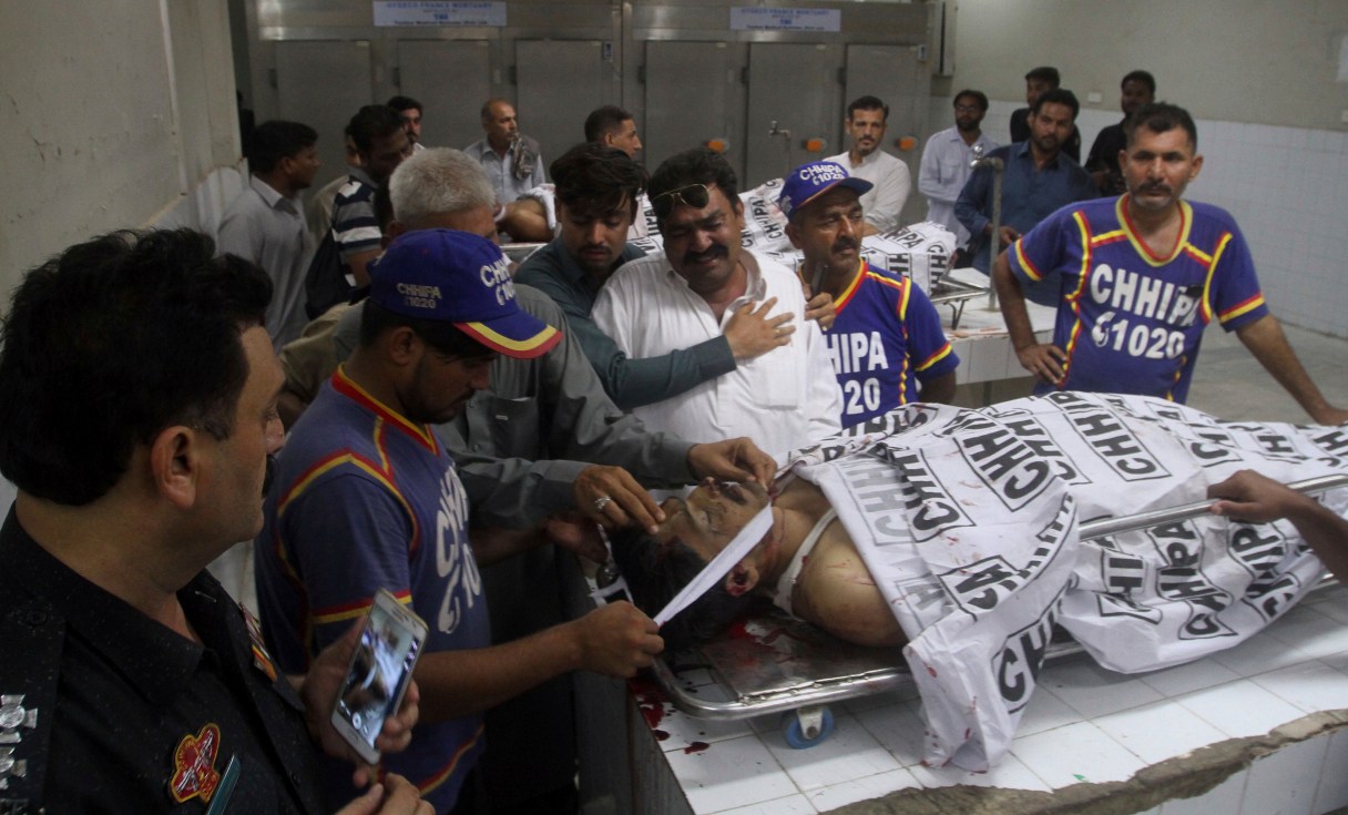 Relatives mourn next to the body of a police officer killed by gunmen, at a morgue of a hospital in Karachi, Pakistan, Friday, June 23, 2017. Gunmen in the port city of Karachi attacked police officers at a roadside restaurant and killed four of them before fleeing, according to senior police officer Asif Ahmed. (AP Photo/Fareed Khan)