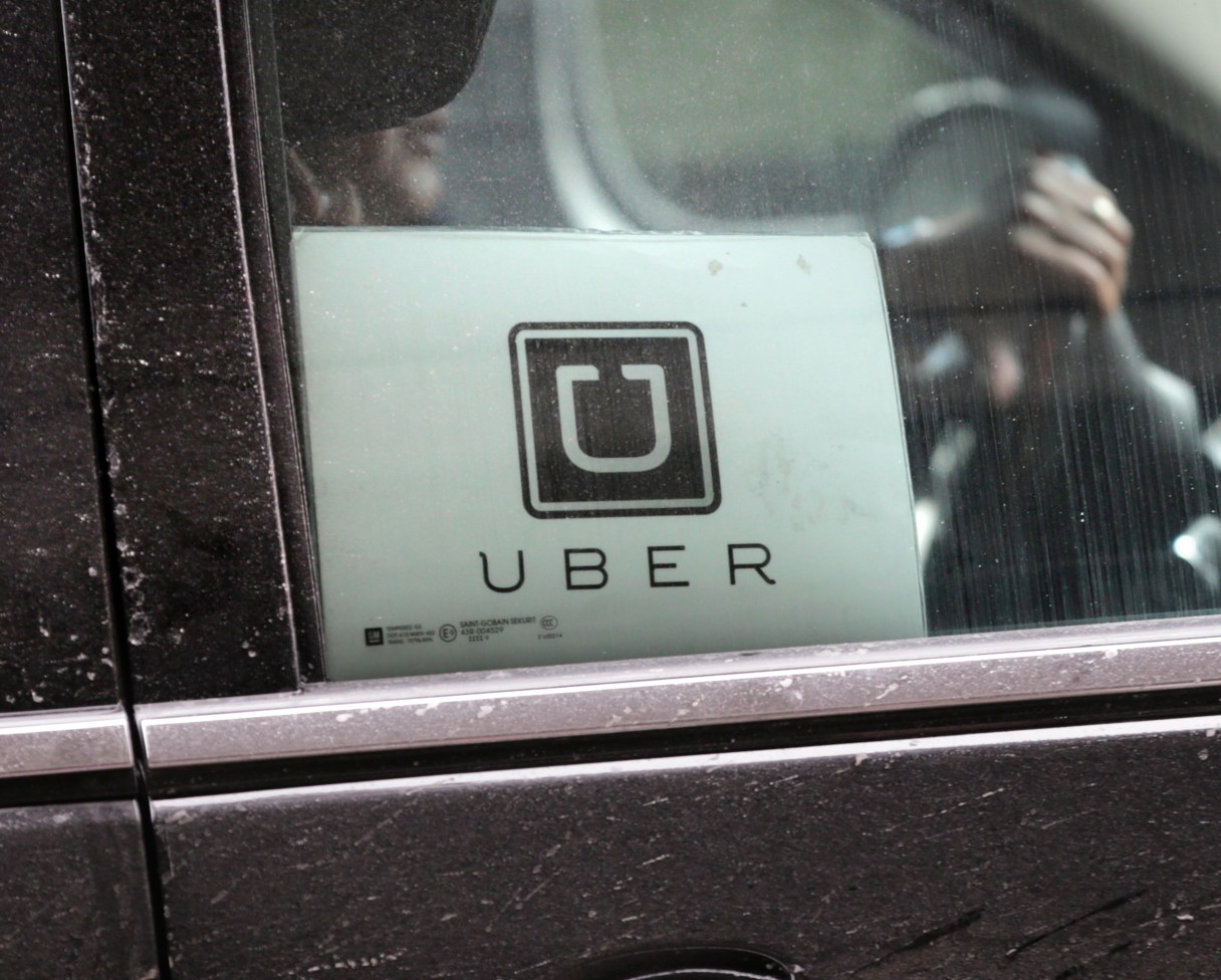 FILE - In this Wednesday, March 15, 2017, file photo, an Uber car drives through LaGuardia Airport in New York. Uber is enabling passengers to tip its U.S. drivers with a tap on its ride-hailing app for the first time, part of a push to recast itself as a company with a conscience and a heart. Besides the built-in tipping option announced Tuesday, June 20, 2017, Uber is giving drivers an opportunity to make more money when passengers keep them waiting or don’t cancel rides within two minutes. (AP Photo/Seth Wenig, File)