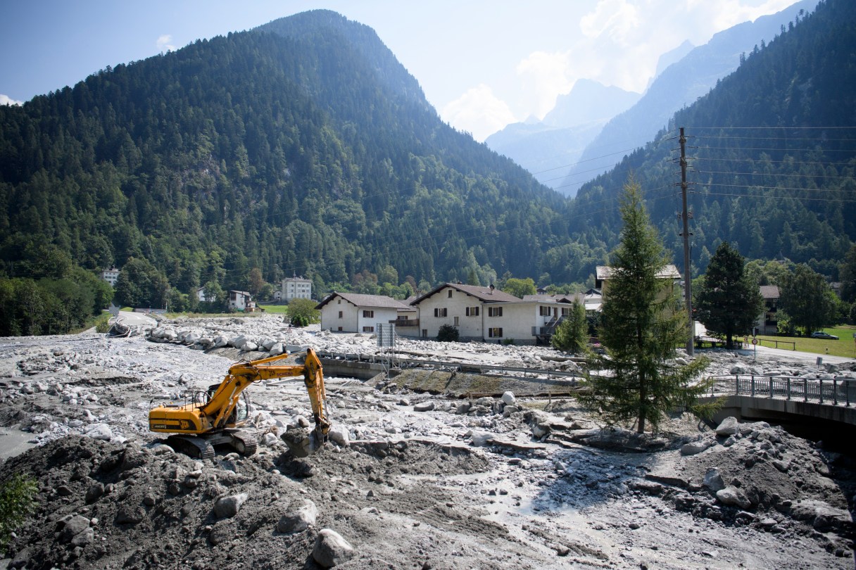 An excavator works on the landslide in Bondo, Graubuenden in southern Switzerland, Friday, August 25, 2017. Police in eastern Switzerland says some residents of a village pummeled by a rocky mudslide have been authorized to return home, as searchers resumed the hunt for eight missing people. (Gian Ehrenzeller/Keystone via AP)
