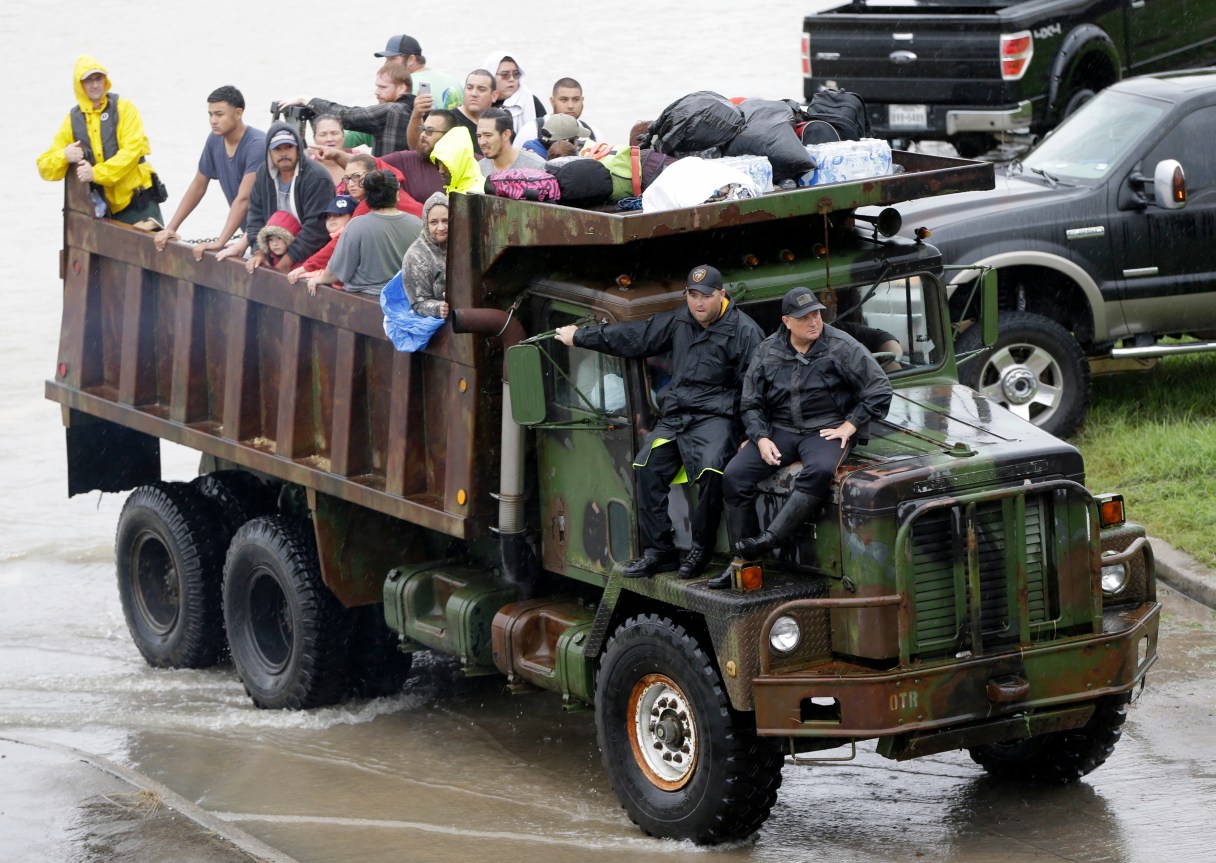 A rescue truck brings people to a street intersection at the east Sam Houston Tollway as evacuations continue from flooding in Houston, Texas, Monday, Aug. 28, 2017, following Tropical Storm Harvey. Floodwaters reached the rooflines of single-story homes Monday and people could be heard pleading for help from inside as Harvey poured rain on the Houston area for a fourth consecutive day after a chaotic weekend of rising water and rescues. (Melissa Phillip/Houston Chronicle via AP)