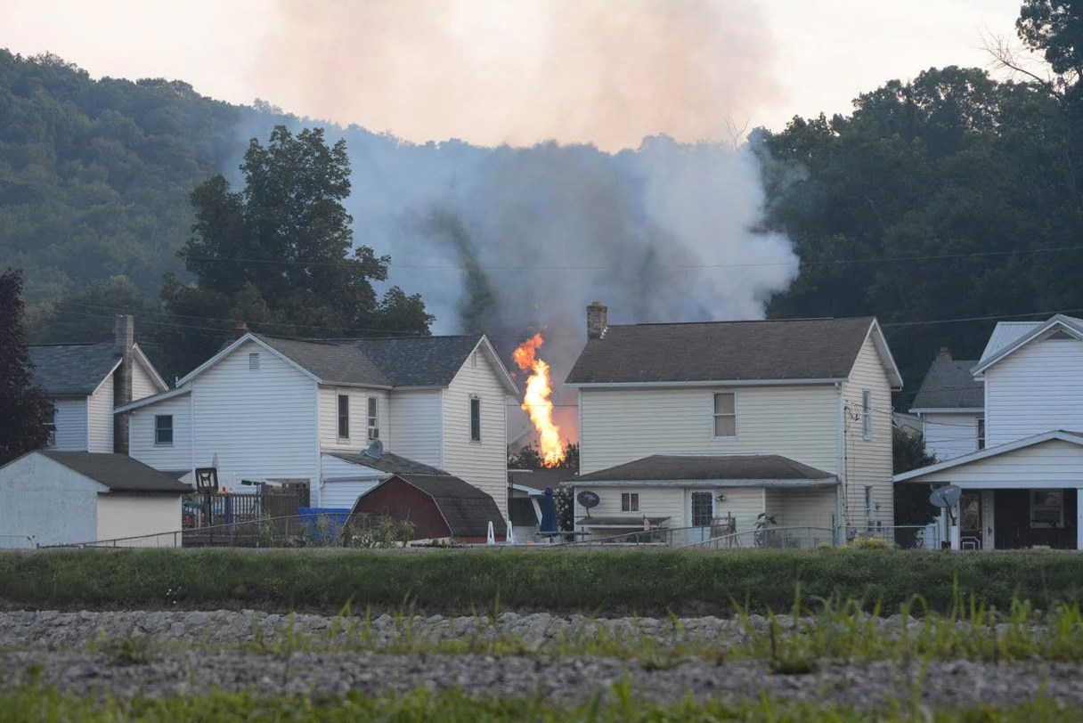 A fire burns at the site of a freight train derailment, Wednesday, Aug. 2, 2017, in Hyndman, Pa. A freight train carrying hazardous materials partly derailed early Wednesday, setting train cars and a garage on fire and prompting emergency officials to evacuate nearby residents. (Steve Bittner/The Cumberland Times-News via AP)