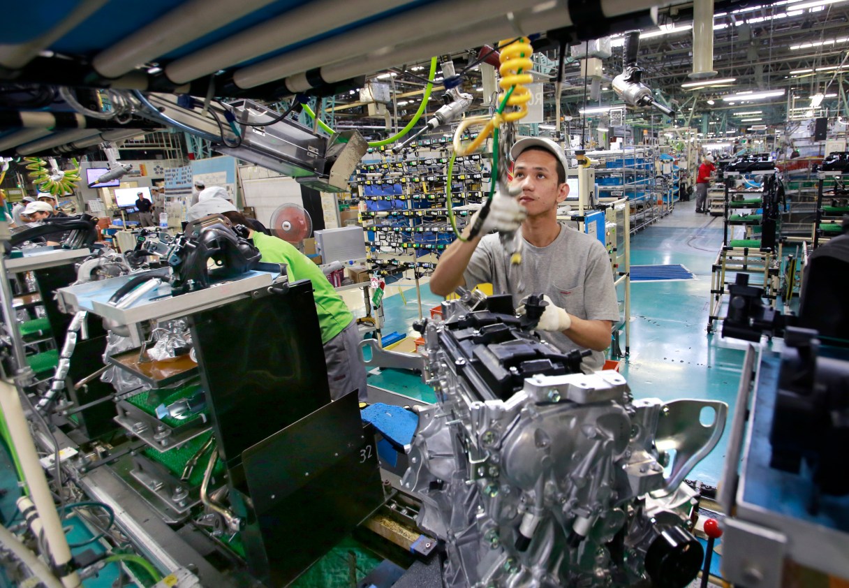In this Aug. 2, 2017, photo, Nissan Motor Co. factory workers check engines on an assembly line at its plant in Yokohama, near Tokyo. Aiming to get an edge on its rivals in an intensely competitive industry, Japanese automaker Nissan says it’s attempting to foster a corporate culture that will produce manufacturing innovations in leaps and bounds instead of steady incremental improvement. Its discussion of that effort is partly a swipe at bigger competitor Toyota Motor Corp. which for decades has favored the concept of “kaizen” or fine tuning and bit-by-bit progress in auto manufacturing. (AP Photo/Shizuo Kambayashi)