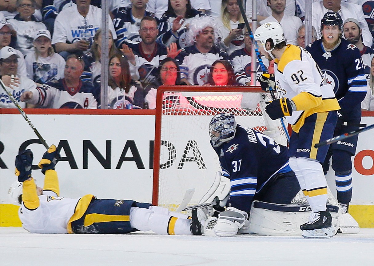 Nashville Predators' Filip Forsberg (9) and Ryan Johansen (92) celebrate Forsberg's goal against Winnipeg Jets goaltender Connor Hellebuyck (37) during second period NHL hockey playoff action in Winnipeg, Manitoba, Monday, May 7, 2018. (John Woods/The Canadian Press via AP)