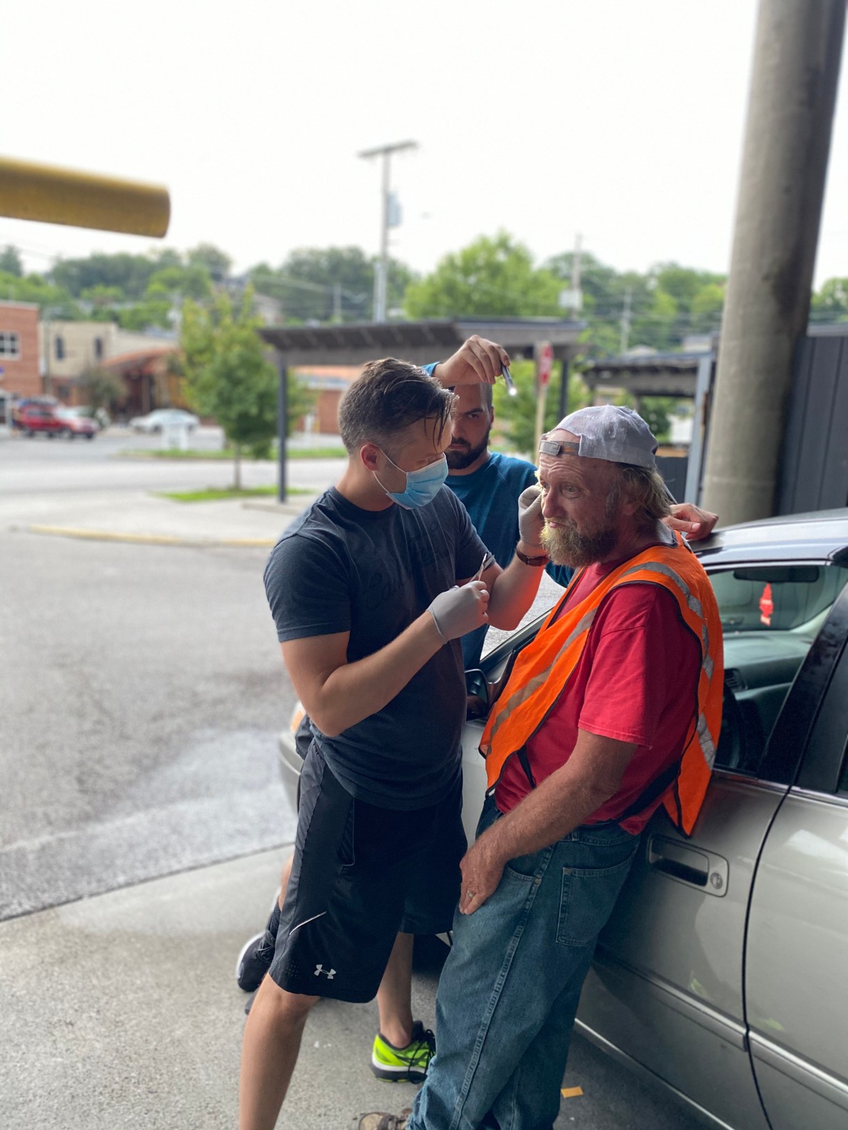 Dr. Jeffrey Atherton is seen here removing several expired stitches for parking garage attendant, "Junior," who had been injured after defending his wife from an attacker several weeks ago. Junior hadn't been able to go back to the hospital since the incident, and Dr. Atherton was just coming off a shift in the ER. / Contributed photo by Kyter Steffes
