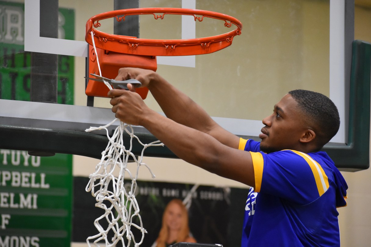 Boyd Buchanan senior John Craw cuts down the final piece of the net after helping the Buccaneers win a second straight Division II-A East District 2 championship at Notre Dame on Saturday night.