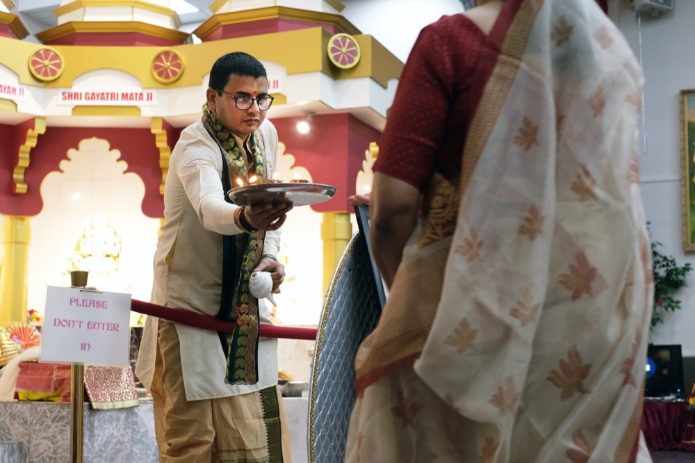 Staff photo by Wyatt Massey / Sunil Shastri, the priest of Sanatan Mandir of Chattanooga, hands out candles during a Gayatri Jayanti celebration at the temple on June 20, 2021.