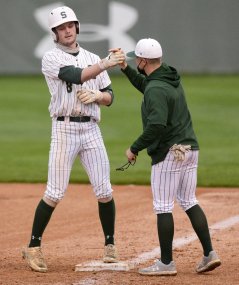 Staff Photo by Robin Rudd / Silverdale's Sebastian Hanks (8) is congratulated by the first base coach after reaching first safely. The South Pittsburg Pirates visited the Silverdale Seahawks in TSSAA baseball on March 23, 2021.