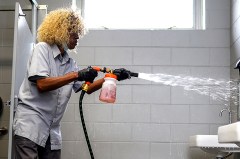 Staff photo by Olivia Ross / Mae Washington sprays down the restroom with cleaning solution on April 29, 2022. She has worked as a custodian with Tennessee Riverpark for nearly 20 years. Washington's daily tasks include cleaning the restrooms, keeping the grounds litter free, and more.