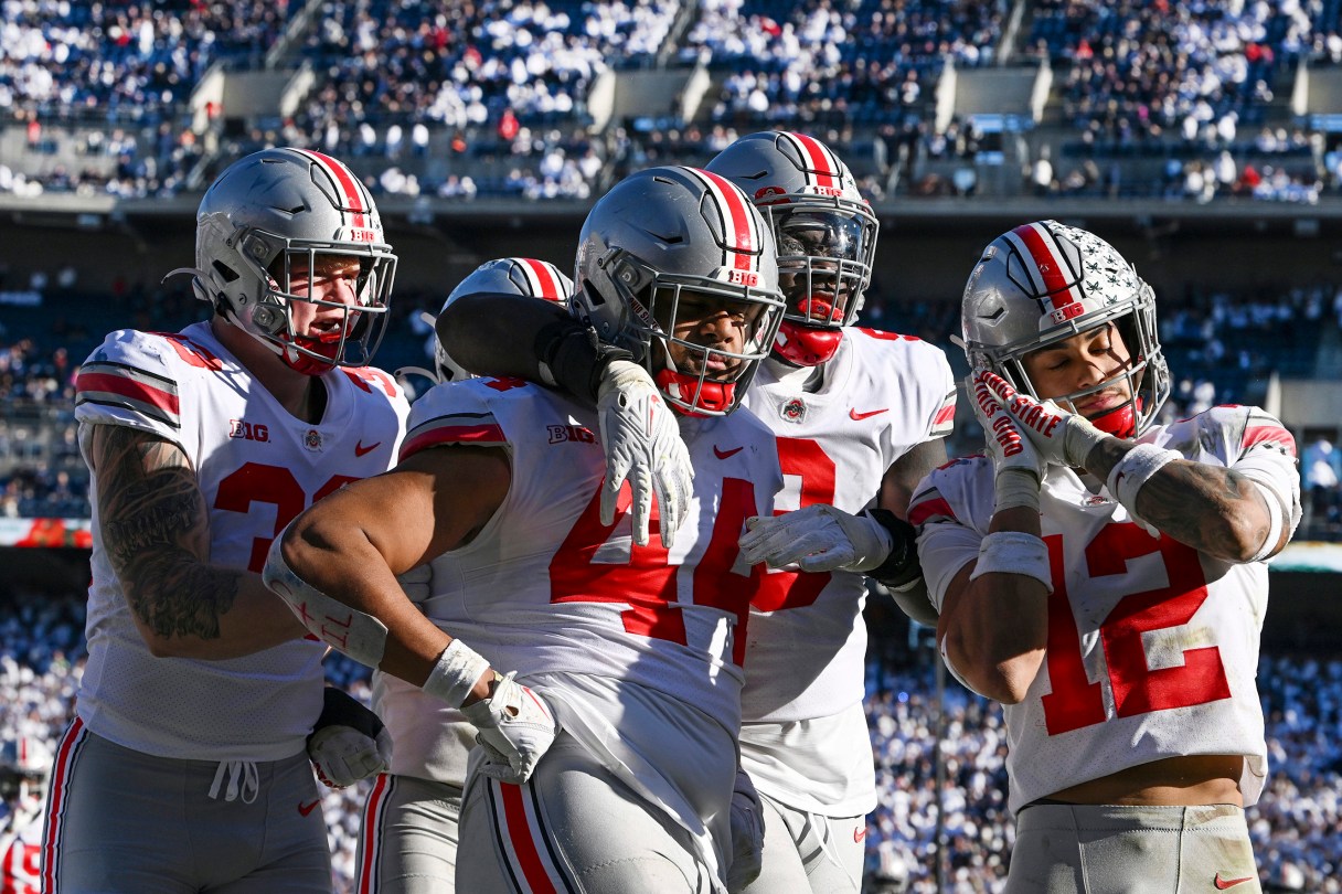 AP photo by Barry Reeger / Ohio State defensive end J.T. Tuimoloau (44) celebrates with Jack Sawyer, left, Zach Harrison, second from right, and Lathan Ransom after returning an interception for a touchdown during the fourth quarter of the Buckeyes' Oct. 29 win at Penn State.