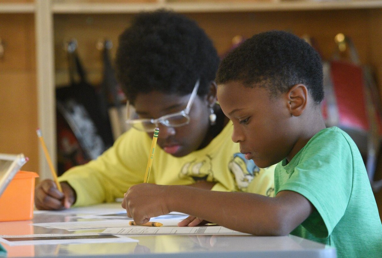 Staff Photo by Matt Hamilton / Kobi Higgins, front, and Cyanna Bryant, both 10, work on a reading worksheet at Battle Academy on June 7.