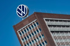 FILE - The Volkswagen logo stand on the top of a VW headquarters building in Wolfsburg, Germany, Monday, April 27, 2020. Volkswagen profits fell 30% in the first three months of the year despite booming business in Europe and North America because sales dropped in China, where the German automaker is facing increasing competition from homegrown models. (Swen Pfoertner/dpa via AP, File)