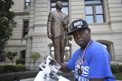 Singer and civil rights activist “General” Larry Platt shares photos and stories next to a statue of Martin Luther King Jr. at the Georgia Capitol. / Georgia Recorder Photo by Ross Williams