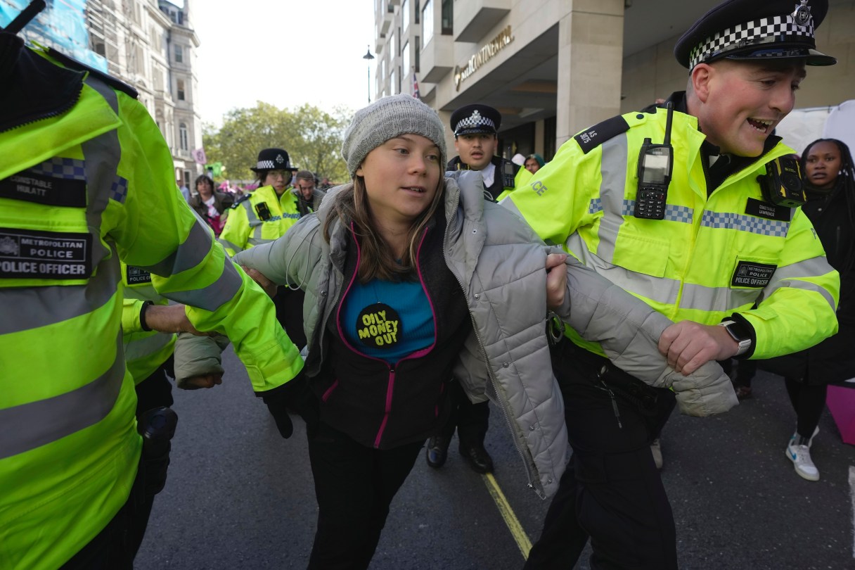 Environmental activist Greta Thunberg ais taken away by police officers during the Oily Money Out protest outside the Intercontinental Hostel, in London, Tuesday, Oct. 17, 2023. (AP Photo/Kin Cheung)