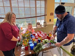 Staff photo by Jennifer McNally / From left, Heather, Madelyn and Nick Pierce showed up as a family Jan. 4, 2025, to help spread cheer with Flower the People at the Life Care Center of Ooltewah.
