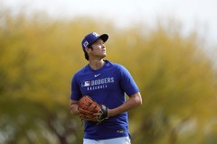 Los Angeles Dodgers' Shohei Ohtani, of Japan, pauses while warming up with pitchers and catchers at the Dodgers baseball spring training facility Tuesday, Feb. 11, 2025, in Phoenix. (AP Photo/Ross D. Franklin)