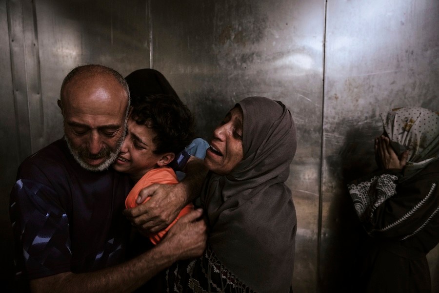 Raed Salem Aslyieh, left, from Jabaliya, hugs his relatives after the death of his son, Ahmed Raed Aslyieh, 18, who succumbed to injuries sustained in an Israeli strike that killed eight other family members four months earlier, worsened by a lack of proper treatment due to medicine shortages, at the morgue of Shifa Hospital in Gaza City, Wednesday, Aug. 6, 2025. (AP Photo/Jehad Alshrafi)