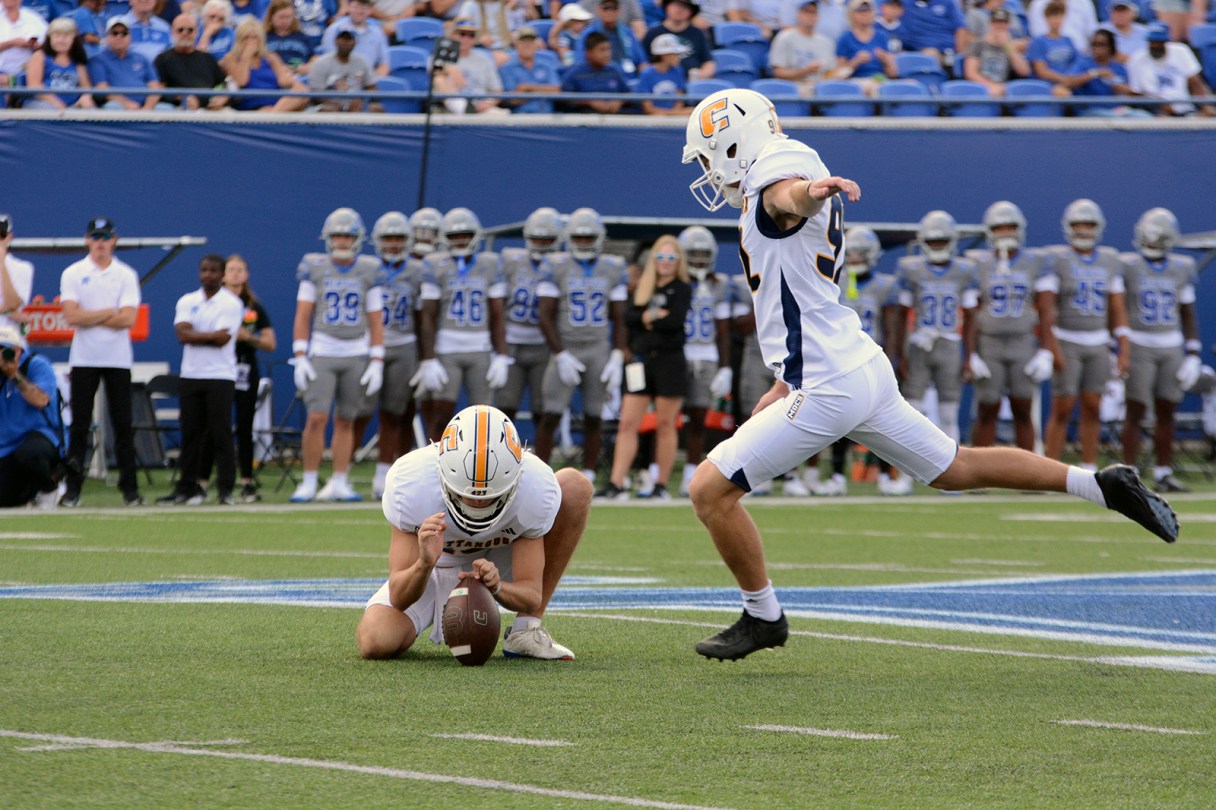 GoMocs.com photo by Laura O'Dell / Heath Jehu holds as Jude Kelley kicks for UTC during the Aug. 30 season opener at Memphis.