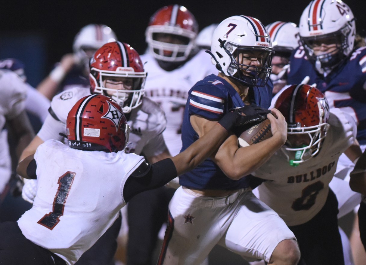 Staff photo by Matt Hamilton / Heritage running back Brayden Slaughter carries the ball as the defense for visiting Harlem closes in during Friday night's game at Jeff Sims Field in the first round of the GHSA Class AAA playoffs.