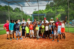 Contributed photo by Xavier Cotto / Players, coaches and volunteers with Southside Youth Development stand with two Chattanooga Lookouts players at home plate at Emma Wheeler Field in June 2025.