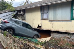 This photo provided by Heather Nakahara shows a car submerged near a flooded home Saturday, March 21, 2026, after flooding in Waialua, Hawaii. (Heather Nakahara via AP)