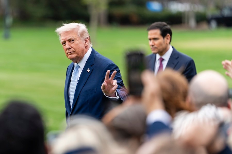 President Donald Trump gestures before boarding Marine One outside of the White House in Washington, on Friday, March 20, 2026. U.S. warplanes and attack helicopters have ramped up assaults against Iranian drones and naval vessels in an effort to reopen the Strait of Hormuz, American officials said, as oil prices remained high on Friday. Secretary of State Marco Rubio stands behind Trump. (Eric Lee/The New York Times)
